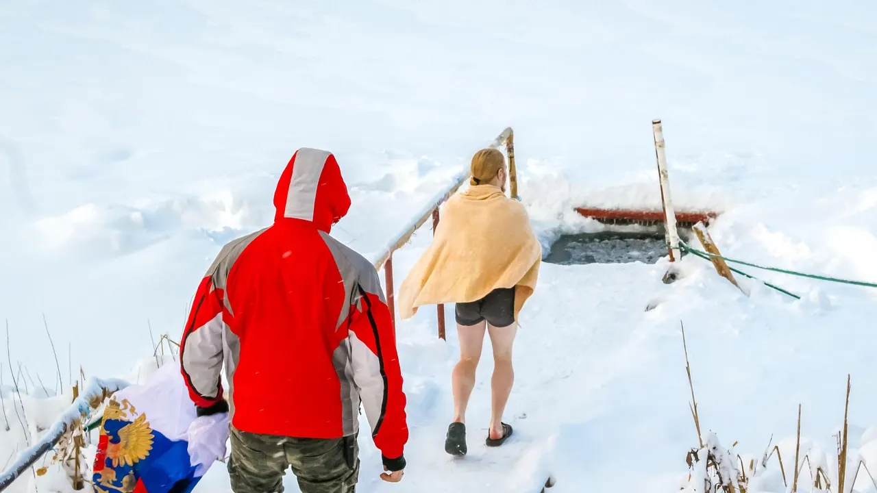 Person som sänker sig i ett kallt isbad utomhus